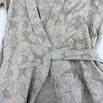 Close-up of a luxurious kimono robe with a subtle floral pattern in soft beige and pastel tones, featuring a matching belt for a sophisticated look.