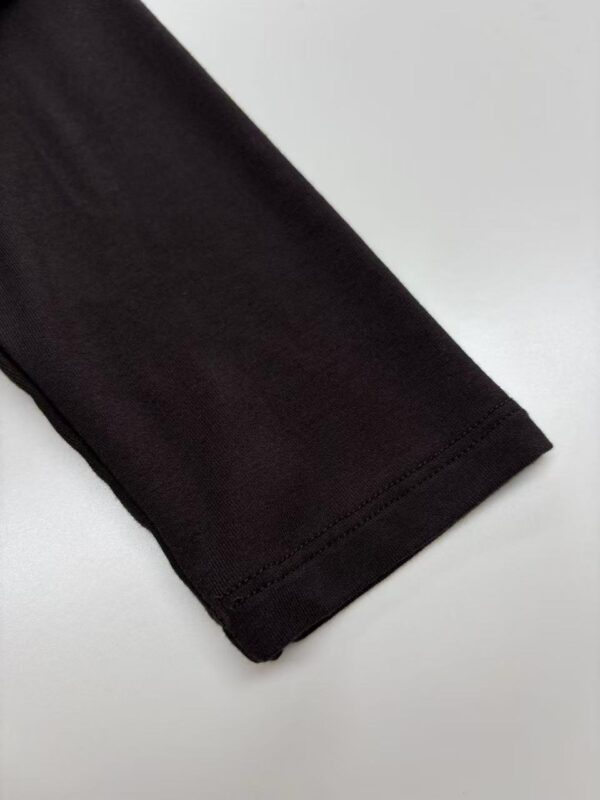 Close-up of a black long sleeve shirt sleeve, showcasing the fabric and stitching details, ideal for men's fashion and casual wear.