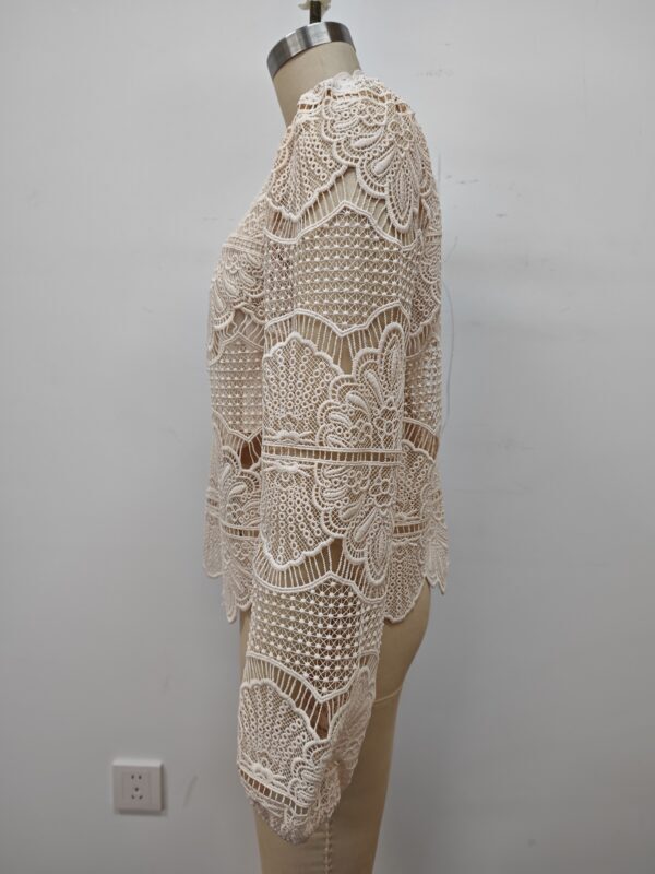 Beautiful beige crochet dress with intricate lace patterns, perfect for summer or special occasions, displayed on a mannequin.