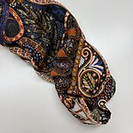 Close-up of a fabric sleeve with vibrant paisley and floral patterns in orange, blue, black, and beige, showcasing detailed textile design.