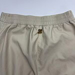 Close-up of beige casual sweatpants with elastic waistband and front zipper, suitable for comfortable everyday wear.