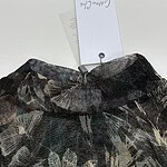 Close-up of a stylish women's skirt with a dark floral pattern, displayed on a white background with a price tag attached.