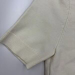 Close-up of a cream-colored sweater sleeve showing ribbed cuff and soft knit fabric, ideal for casual or stylish winter wear.