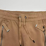 Close-up of men's beige jogger pants with zippered pockets and drawstring waistband, suitable for casual wear and athletic activities.