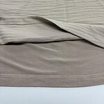 Close-up of a beige bed sheet set with smooth texture and neatly stitched edges, ideal for a stylish bedroom decor.