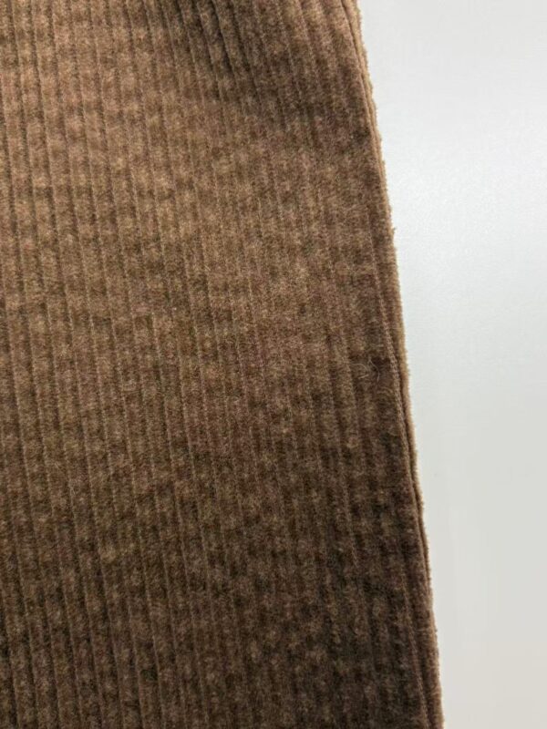 Close-up of brown ribbed fabric showing texture and vertical lines, ideal for fashion and textile product display.
