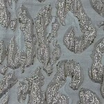Close-up of luxurious fabric featuring intricate embroidery and shimmering silver sequins, perfect for high-end fashion or special occasion garments.