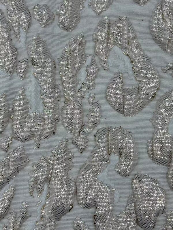 Close-up of luxurious fabric featuring intricate embroidery and shimmering silver sequins, perfect for high-end fashion or special occasion garments.