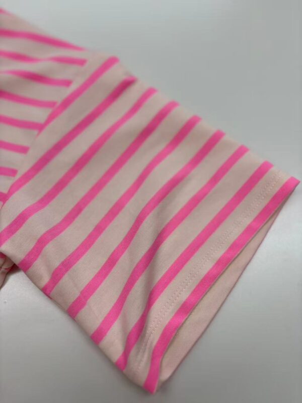 Close-up of pink and beige striped fabric, showcasing the pattern and texture, ideal for fashion or textile product SEO.