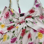 Elegant floral summer dress with pink, yellow, and purple roses, featuring a large bow at the front, perfect for warm weather and outdoor events.