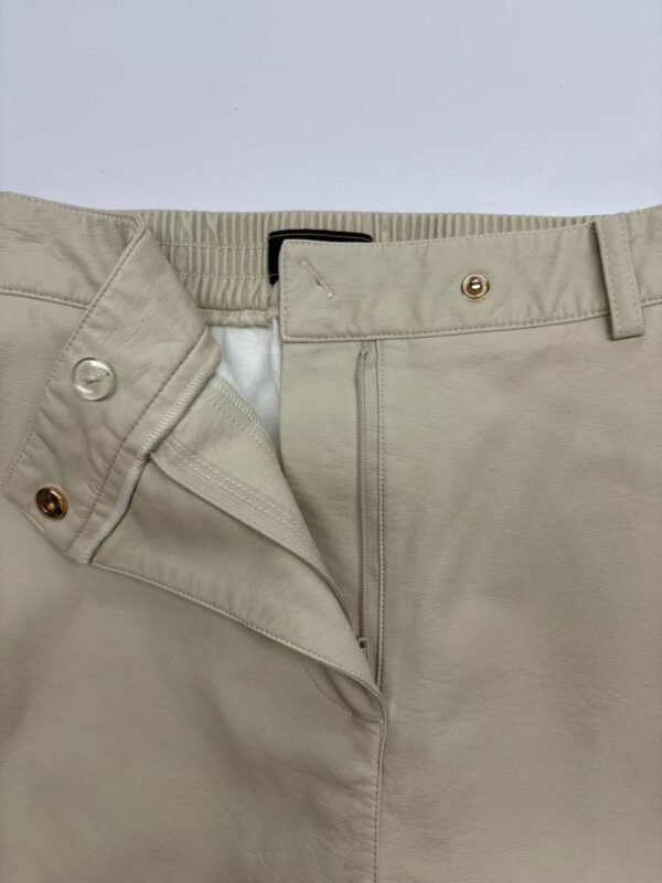 Close-up of beige casual men's pants showing zipper, button, and belt loops, suitable for everyday wear and stylish comfort.