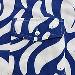 Close-up of a blue and white patterned shirt with a pocket and button detail, perfect for casual or summer fashion.
