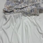 Close-up of luxurious fabric with floral pattern and smooth silk skirt, showcasing high-quality textile craftsmanship.