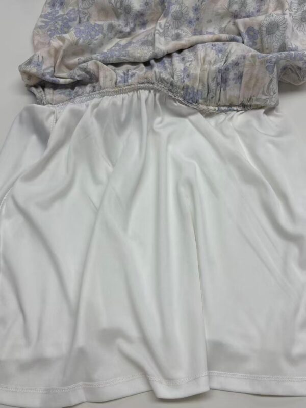 Close-up of luxurious fabric with floral pattern and smooth silk skirt, showcasing high-quality textile craftsmanship.