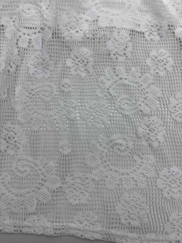 Close-up of intricate white lace fabric with floral and geometric patterns, ideal for fashion and home decor projects.
