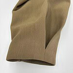 Close-up of khaki fabric with smooth texture and subtle folds, ideal for clothing and fashion accessories.