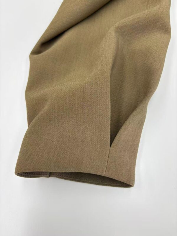 Close-up of khaki fabric with smooth texture and subtle folds, ideal for clothing and fashion accessories.