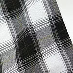 Close-up of black and white plaid fabric with yellow accents, ideal for fashion and clothing design.