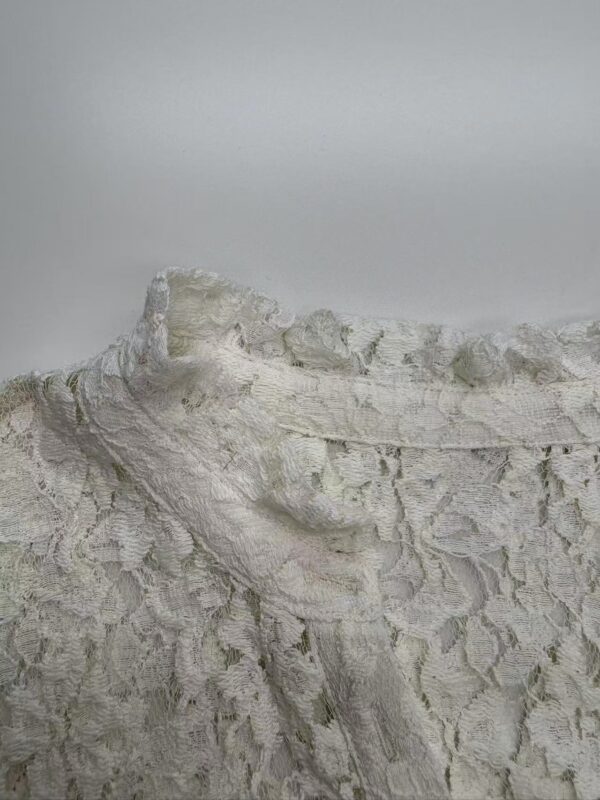 Close-up of white chalk cliffs with detailed surface texture and natural formations, under a cloudy sky.