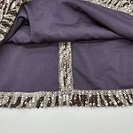 Close-up of a glamorous dress featuring sequins and a purple lining, highlighting intricate details and luxurious fabric for evening wear or special occasions.
