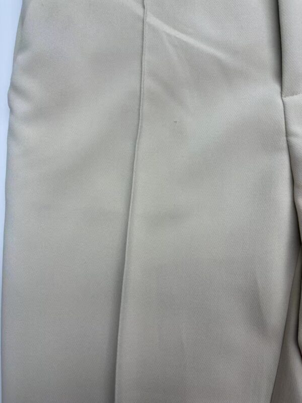 Close-up of smooth, light gray fabric with subtle texture and stitching details, ideal for fashion or upholstery applications.