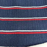 Close-up of navy blue knit fabric with red and white horizontal stripes, showcasing textured material and detailed pattern.