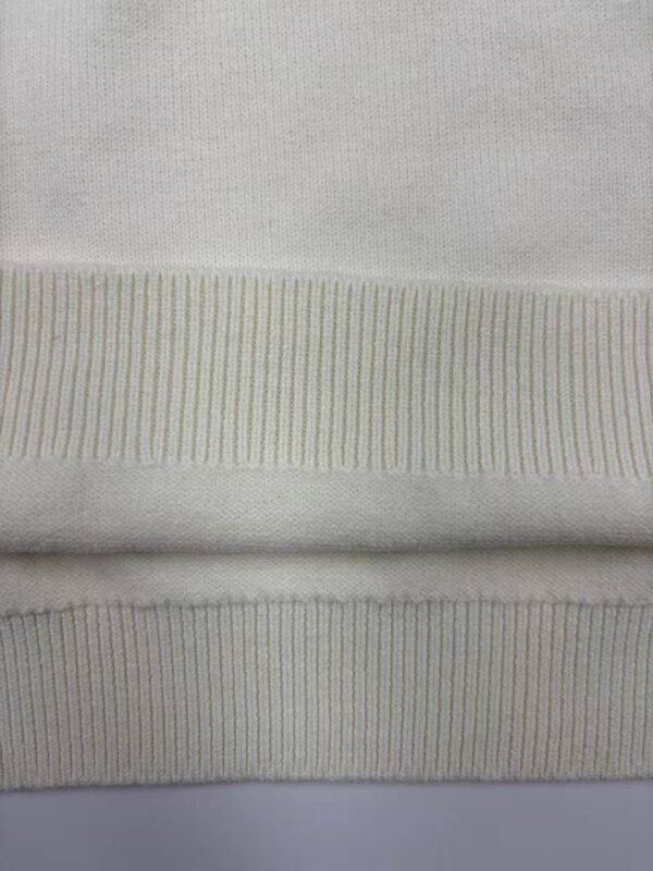 Detailed close-up of white knit fabric showing fine texture and ribbed pattern, ideal for fashion and textile product display.