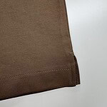 Close-up of brown fabric with stitched hem, showcasing smooth texture and neat finishing.