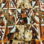 Close-up of vibrant African tribal pattern fabric with geometric shapes in orange, black, white, and yellow colors, showcasing traditional textile design.