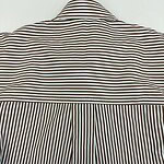 Close-up of a striped shirt showcasing horizontal stripes on the upper part and vertical stripes on the pleated back, emphasizing fashion and design details.
