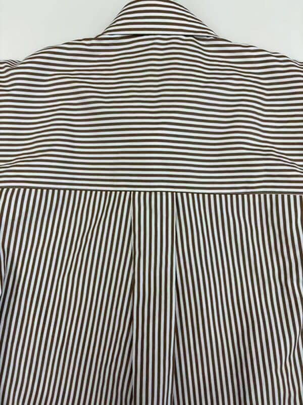 Close-up of a striped shirt showcasing horizontal stripes on the upper part and vertical stripes on the pleated back, emphasizing fashion and design details.