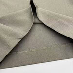 Close-up of khaki fabric with smooth texture and subtle stitching, ideal for stylish clothing and fashion accessories.