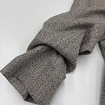 Close-up of a herringbone wool coat sleeve showcasing detailed fabric texture and craftsmanship, perfect for fall and winter fashion.