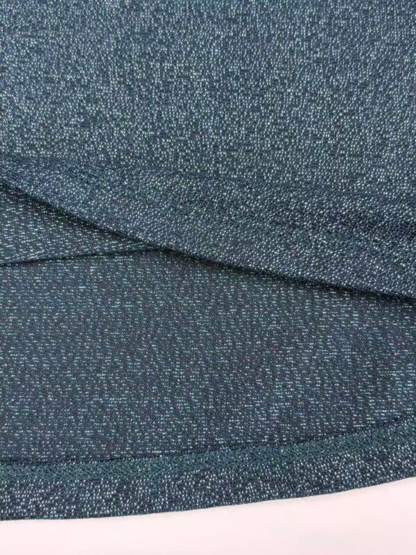 Close-up of shimmering teal fabric with tiny reflective particles, ideal for stylish clothing and accessories.