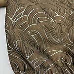 Close-up of a brown dress with intricate sequin embroidery and textured fabric, showcasing luxurious design and craftsmanship.