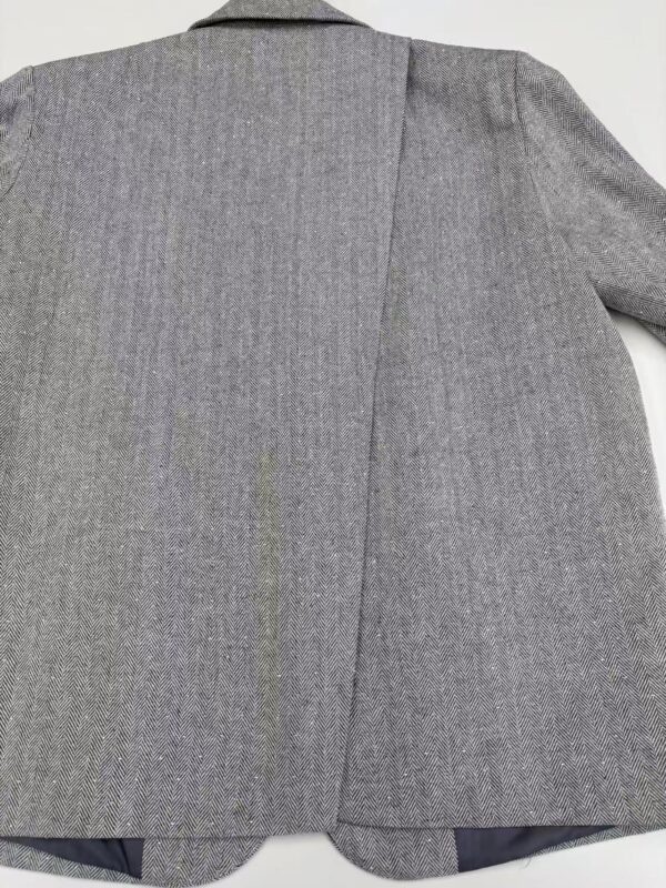 Close-up of a tailored grey business blazer for women, showcasing the fabric texture and professional style, ideal for office wear and formal occasions.