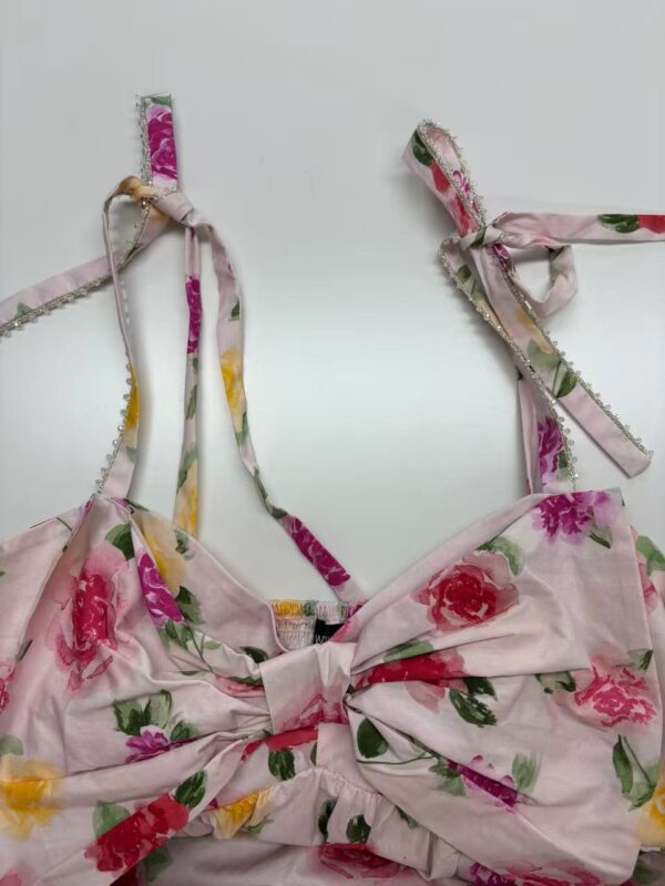 Pink floral summer dress with adjustable shoulder straps and a bow at the front, perfect for warm weather and casual outings.