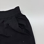 Close-up of black casual jogger pants with elastic waistband and drawstring, suitable for sports and leisure wear.