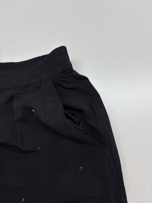 Close-up of black casual jogger pants with elastic waistband and drawstring, suitable for sports and leisure wear.