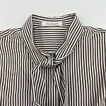 Close-up of a stylish striped blouse with a tie at the collar, perfect for fashion-forward women. Features brown and white vertical stripes and a comfortable fit.