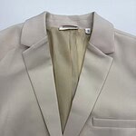 Stylish beige blazer with a classic lapel collar, tailored fit, and sleek design, perfect for professional or casual wear.