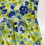 Bright floral summer dress with blue, yellow, and white flowers, featuring a gathered waist and lightweight fabric, perfect for warm weather and casual outings.