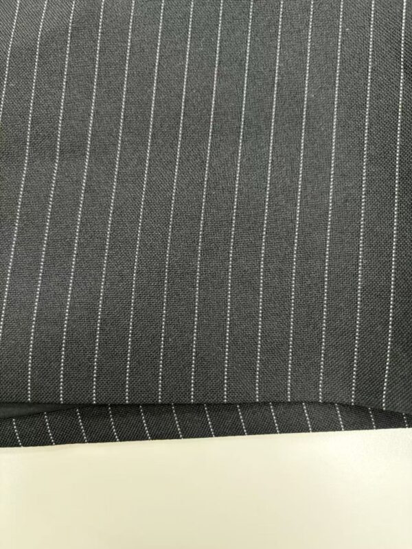 Close-up of dark gray pinstripe fabric with white vertical lines, suitable for business suits or formal wear.