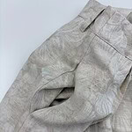 Close-up of light beige linen trousers with subtle leaf pattern, showcasing high-quality fabric and tailored fit, perfect for casual or semi-formal wear.
