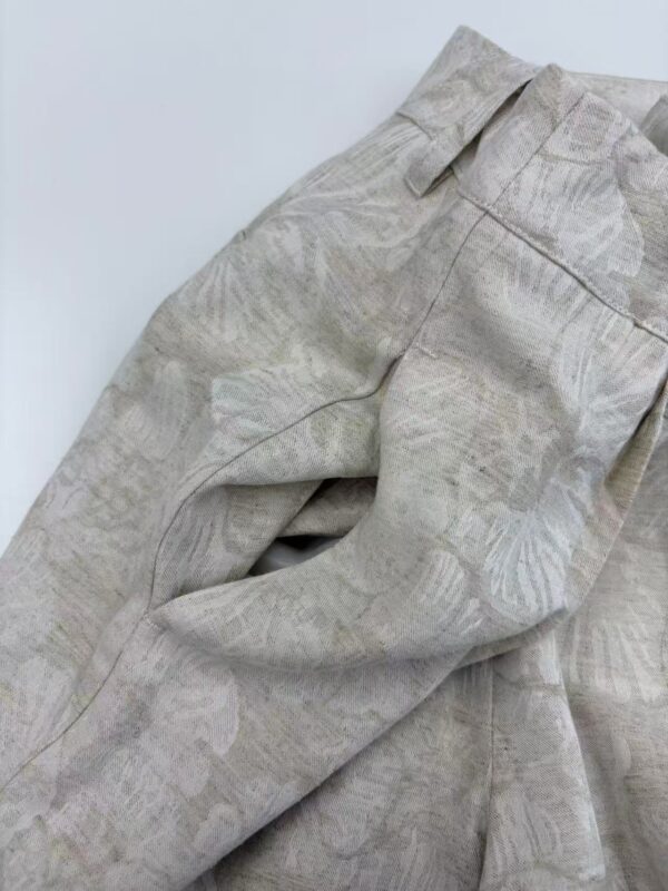 Close-up of light beige linen trousers with subtle leaf pattern, showcasing high-quality fabric and tailored fit, perfect for casual or semi-formal wear.