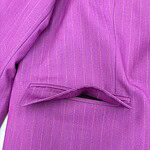Close-up of a pink pinstripe women's suit with a tailored blazer and matching skirt, showcasing professional and stylish office wear.