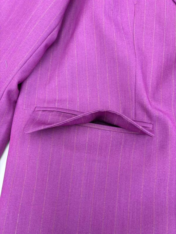 Close-up of a pink pinstripe women's suit with a tailored blazer and matching skirt, showcasing professional and stylish office wear.