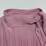 Close-up of a pink pleated skirt with a tied waist, showcasing stylish and feminine fashion suitable for various occasions.