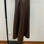 Stylish brown leather wide-leg pants displayed on a mannequin, perfect for fashion-forward outfits and versatile styling.