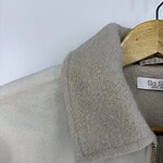 Close-up of a stylish wool coat with a beige collar and zipper, perfect for winter fashion and cold weather wear.